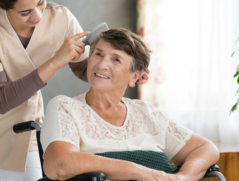 Caring,Volunteer,Combing,Hair,Of,An,Older,Patient,In,A